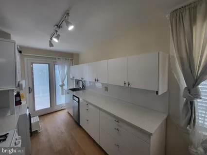 a kitchen with granite countertop a sink stove and refrigerator