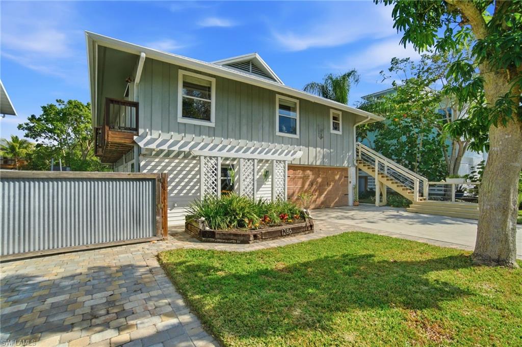 1286 Venetian Way Naples, FL 34110 - Photo 1 of 46 a front view of a house with garden