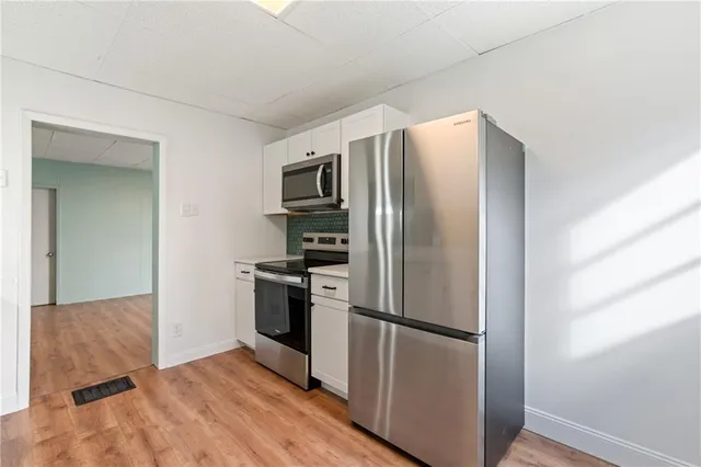 a metallic refrigerator freezer sitting in a kitchen