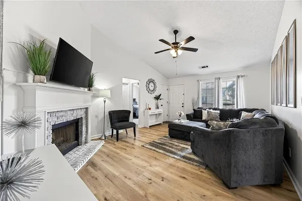a living room with furniture a fireplace and a flat screen tv