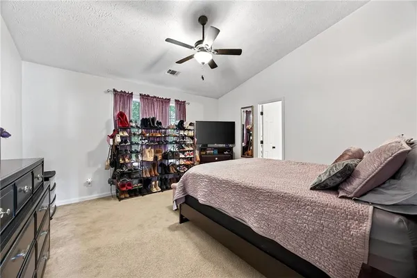 a bed room with a bed and a ceiling fan