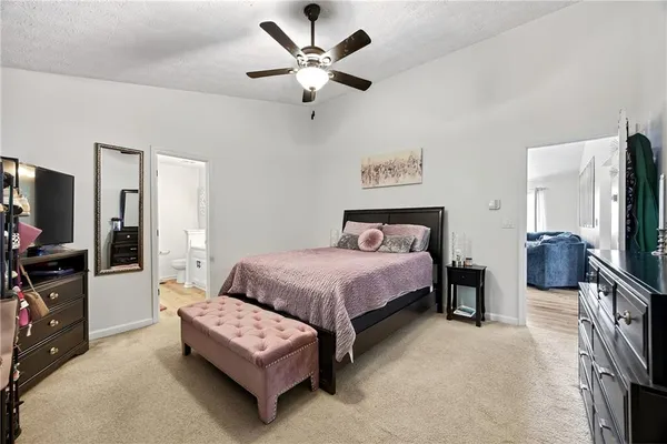 a bedroom with a bed couch and a flat tv screen
