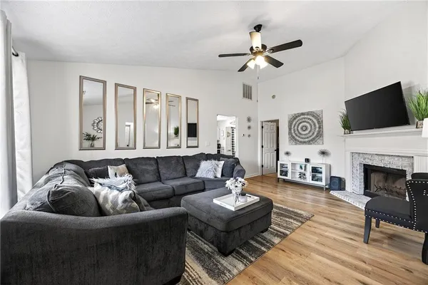 a living room with furniture a fireplace and a flat screen tv