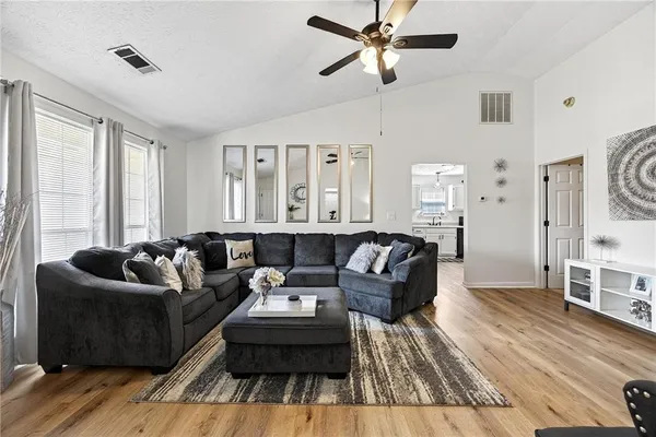 a living room with furniture and a wooden floor
