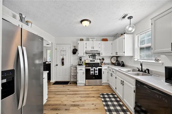 a kitchen with stainless steel appliances a refrigerator sink and cabinets