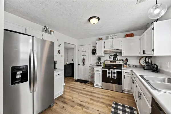 a kitchen with stainless steel appliances granite countertop a refrigerator stove and sink