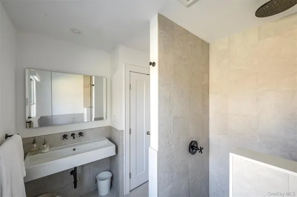 a bathroom with a tub sink and mirror