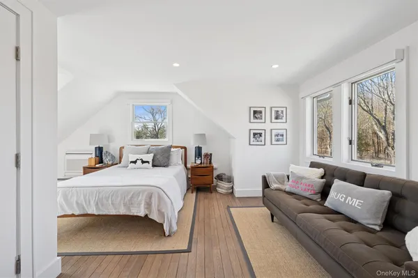 a bedroom with a large bed couch and a window