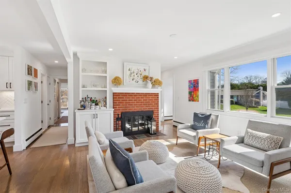 a living room with furniture fireplace and a large window
