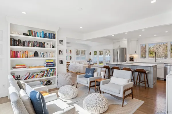 a living room with furniture and a dining table with wooden floor