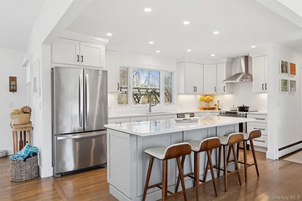 a kitchen with stainless steel appliances granite countertop a refrigerator and a stove top oven