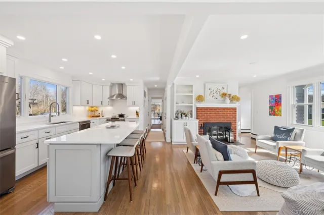 a kitchen with stainless steel appliances a dining table chairs stove refrigerator and cabinets