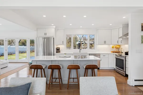 a kitchen with stainless steel appliances granite countertop a kitchen island a stove a table and chairs