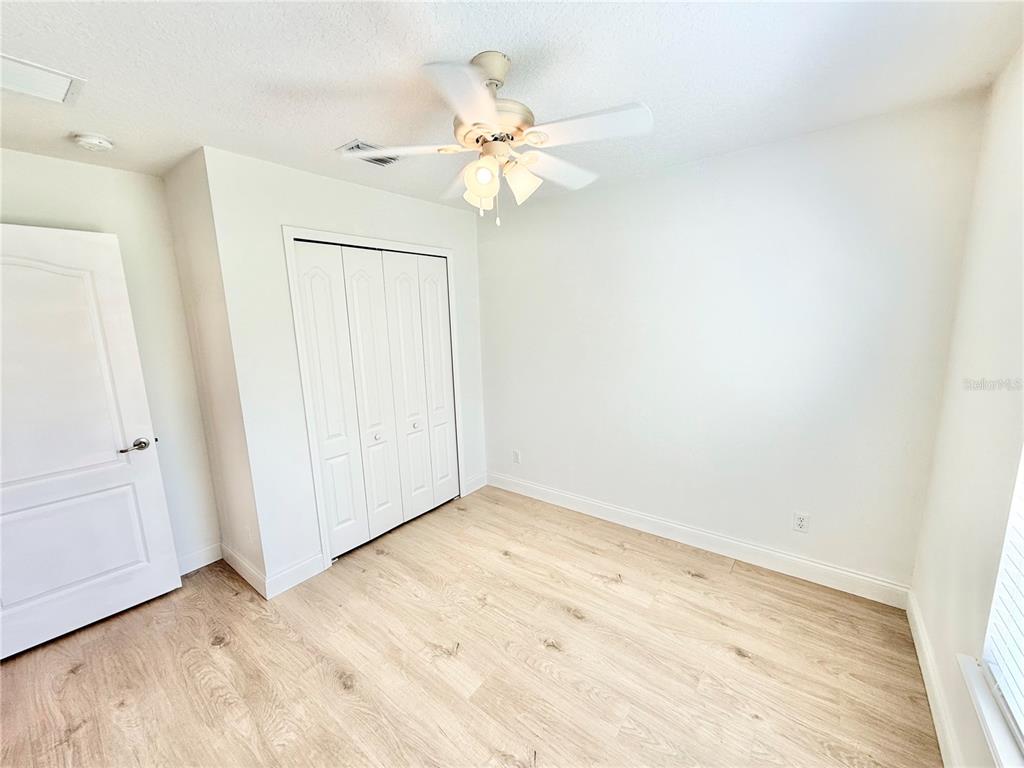 1220 Myrtle Avenue St. Cloud, FL 34771 - Photo 14 of 59 a view of a room with wooden floor and a ceiling fan