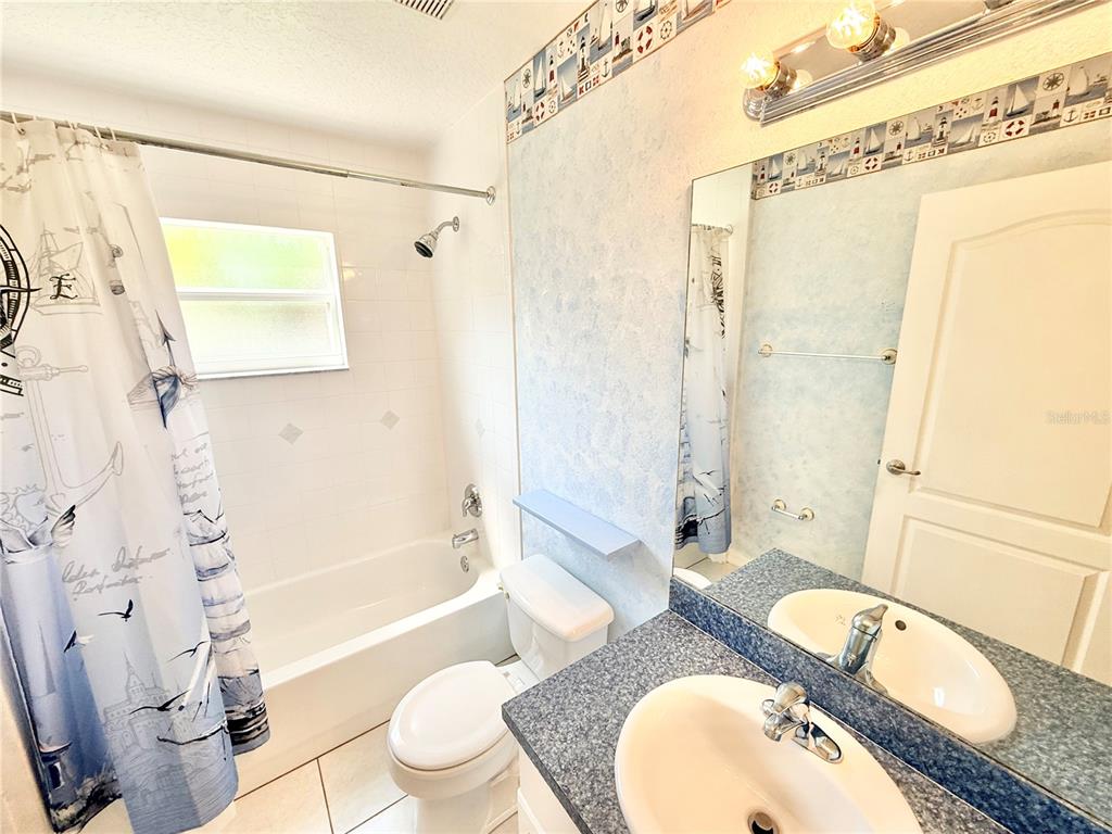 1220 Myrtle Avenue St. Cloud, FL 34771 - Photo 38 of 59 a bathroom with a granite countertop sink mirror toilet and bathtub