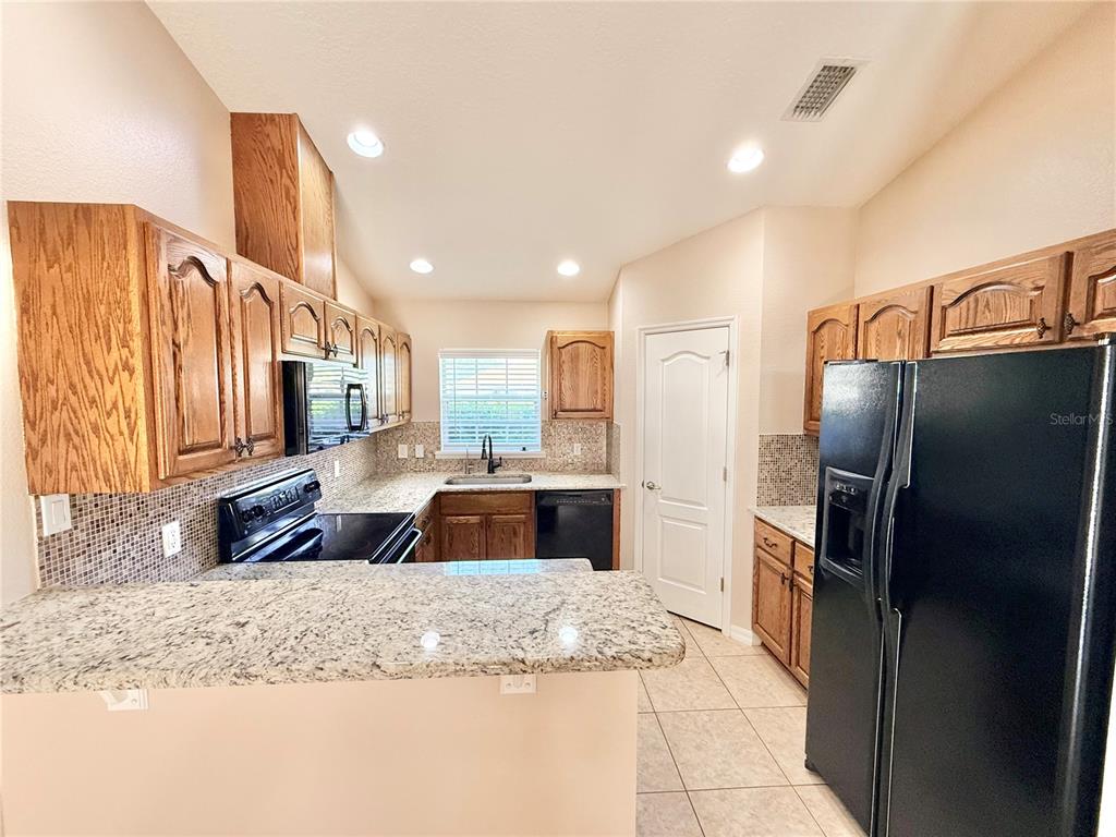 1220 Myrtle Avenue St. Cloud, FL 34771 - Photo 4 of 59 a kitchen with stainless steel appliances granite countertop a refrigerator and a sink