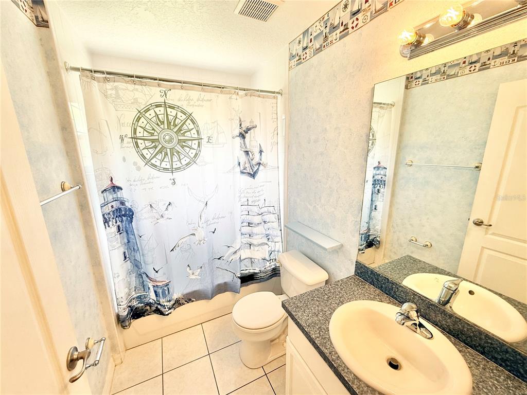 1220 Myrtle Avenue St. Cloud, FL 34771 - Photo 41 of 59 a bathroom with a granite countertop sink mirror vanity and toilet