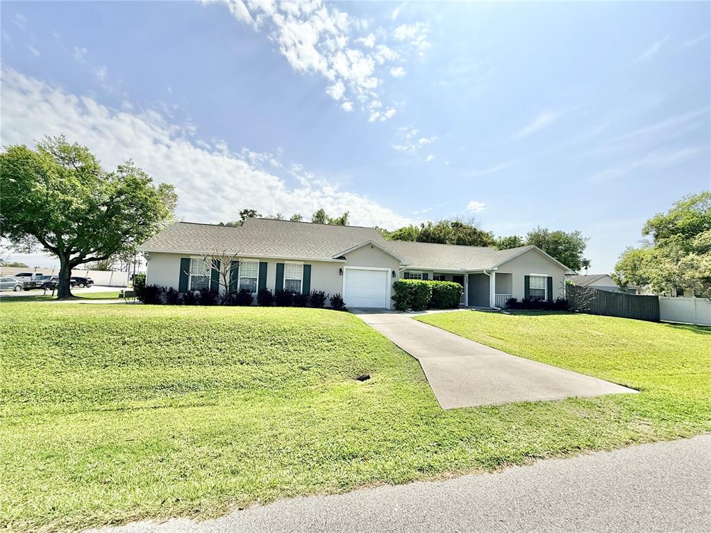 1220 Myrtle Avenue St. Cloud, FL 34771 - Photo 58 of 59 a front view of a house with a garden and trees