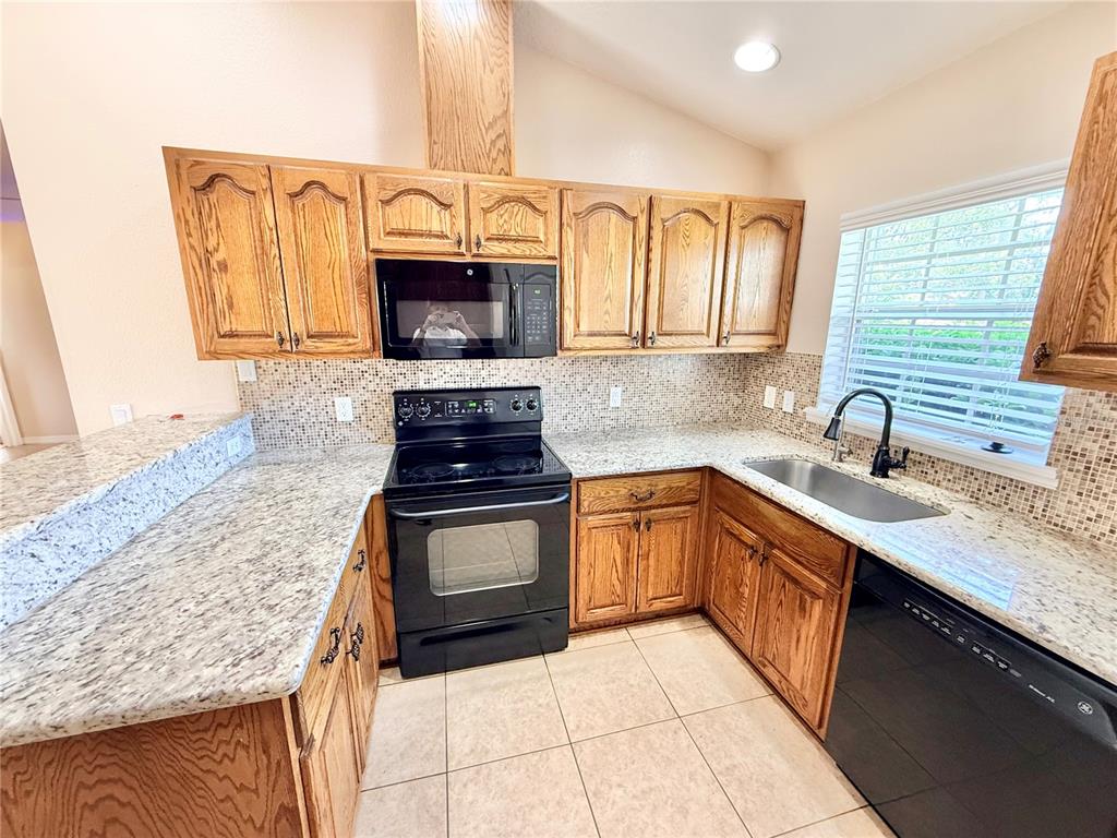 1220 Myrtle Avenue St. Cloud, FL 34771 - Photo 6 of 59 a kitchen with stainless steel appliances granite countertop a sink stove and microwave