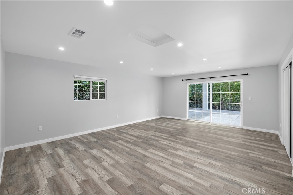19613 Lanark Street, Unit 1/4 Reseda, CA 91335 - Photo 11 of 38 a view of an empty room with wooden floor and a window