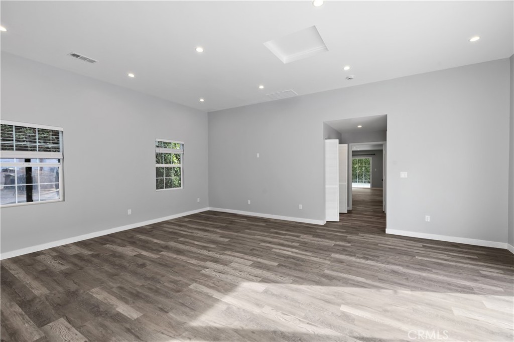 19613 Lanark Street, Unit 1/4 Reseda, CA 91335 - Photo 13 of 38 a view of an empty room with wooden floor and a window