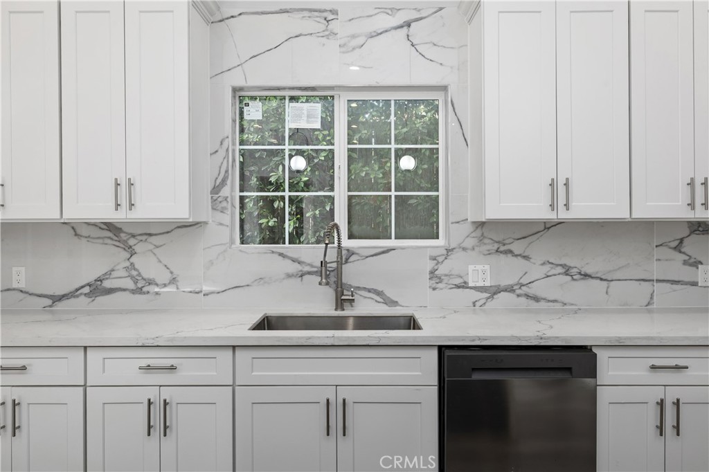 19613 Lanark Street, Unit 1/4 Reseda, CA 91335 - Photo 19 of 38 a kitchen with granite countertop white cabinets and a window