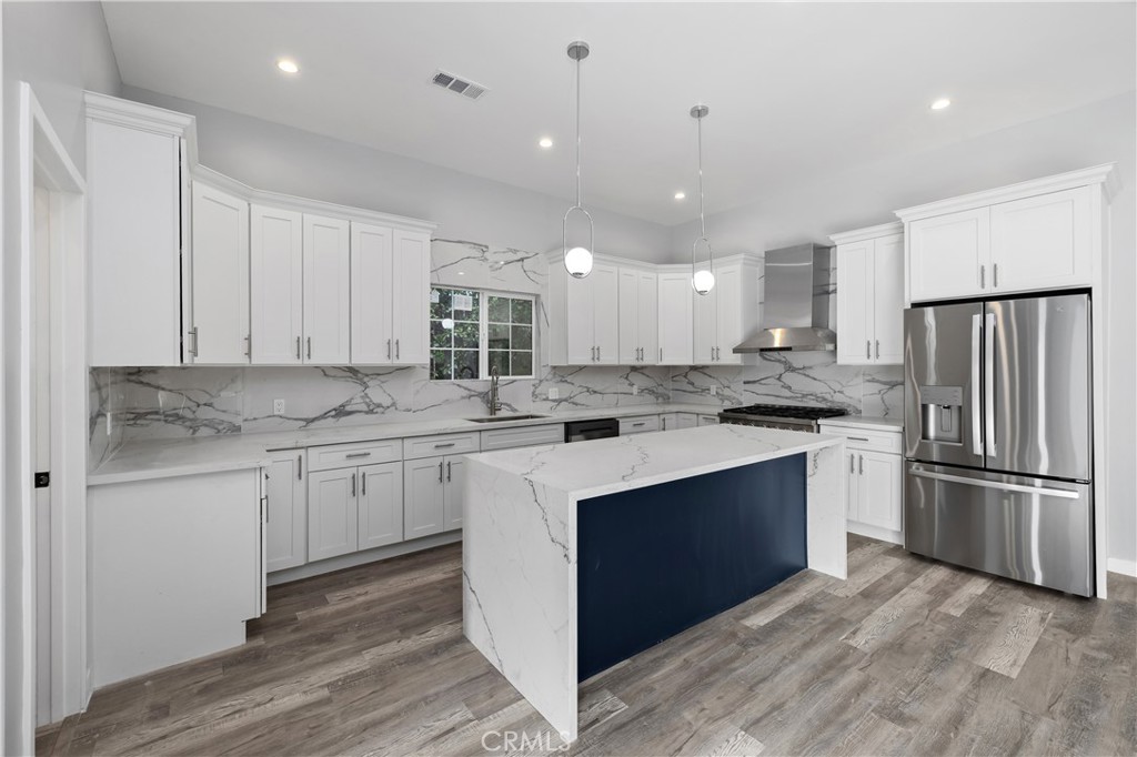 19613 Lanark Street, Unit 1/4 Reseda, CA 91335 - Photo 20 of 38 a kitchen with kitchen island a sink stainless steel appliances and cabinets