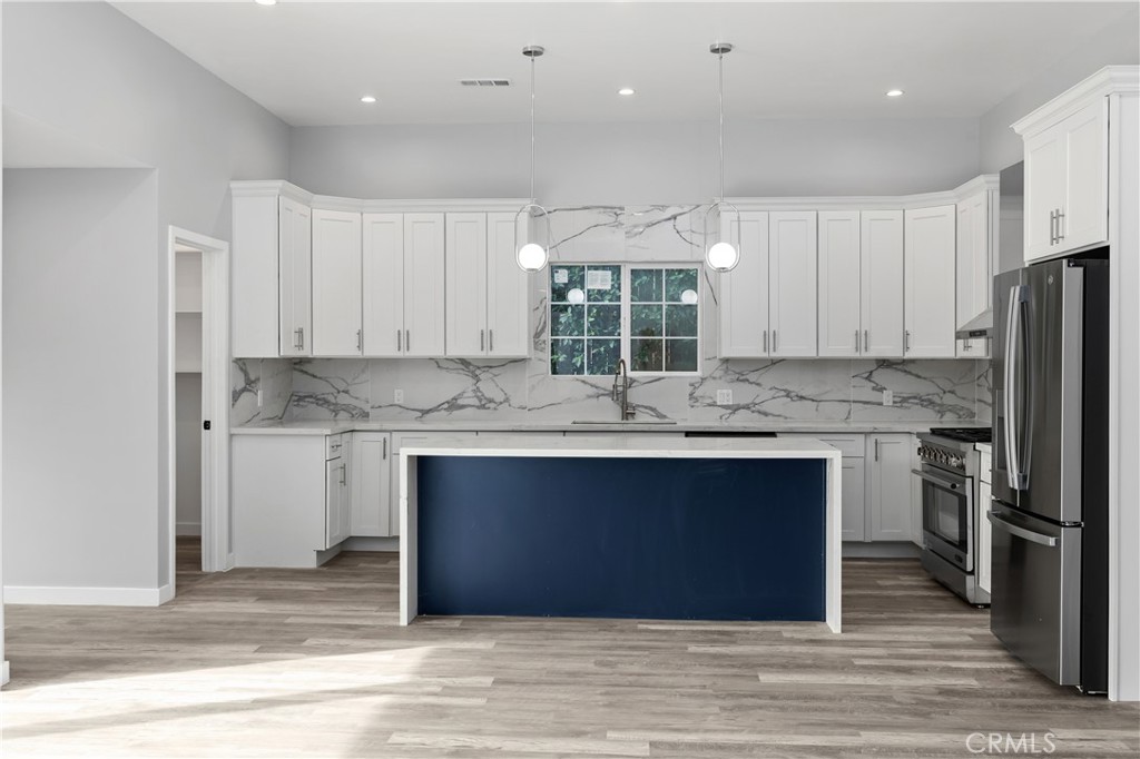 19613 Lanark Street, Unit 1/4 Reseda, CA 91335 - Photo 21 of 38 a kitchen with stainless steel appliances granite countertop a stove a sink and a refrigerator