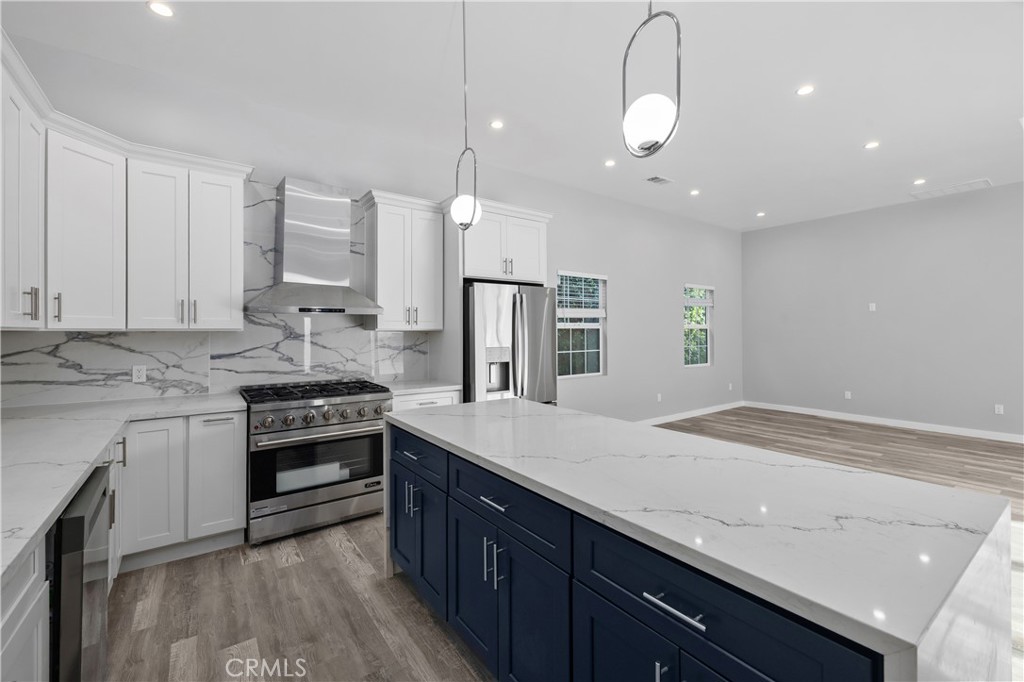 19613 Lanark Street, Unit 1/4 Reseda, CA 91335 - Photo 27 of 38 a kitchen with stainless steel appliances granite countertop a sink a stove and a wooden floors
