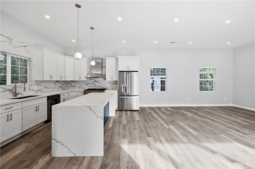 19613 Lanark Street, Unit 1/4 Reseda, CA 91335 - Photo 29 of 38 a kitchen with stainless steel appliances granite countertop a refrigerator a sink dishwasher a stove and white countertops with wooden floor