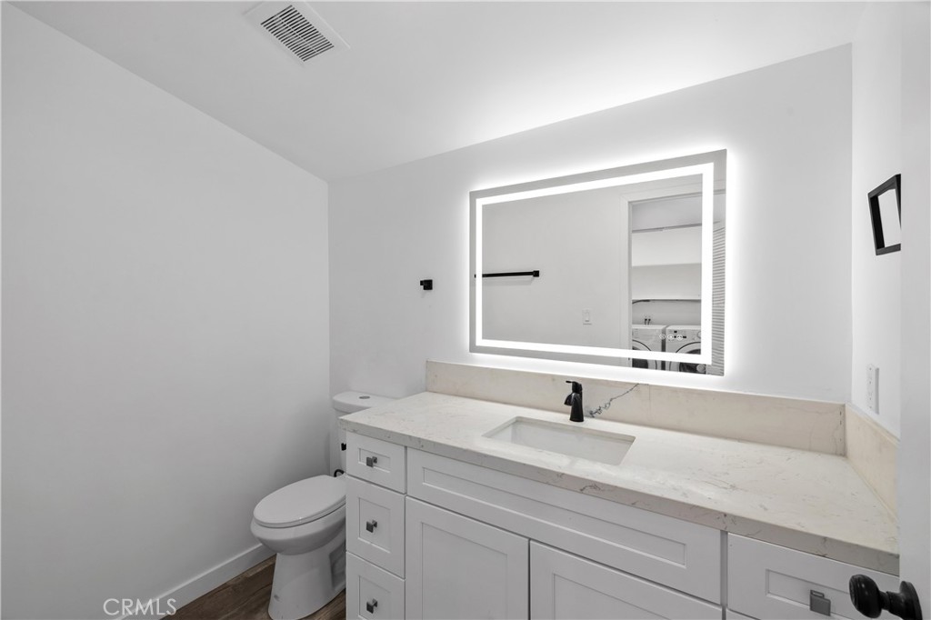 19613 Lanark Street, Unit 1/4 Reseda, CA 91335 - Photo 4 of 38 a bathroom with a toilet a sink and mirror