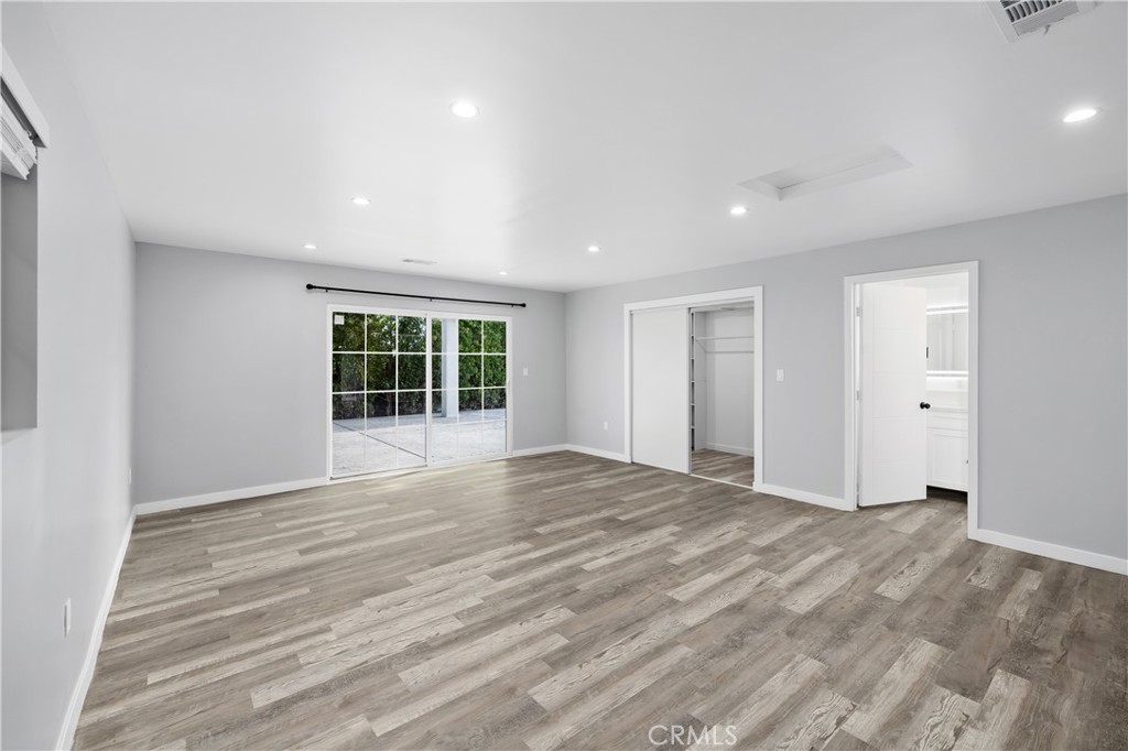 19613 Lanark Street, Unit 1/4 Reseda, CA 91335 - Photo 10 of 38 a view of an empty room with wooden floor and a window