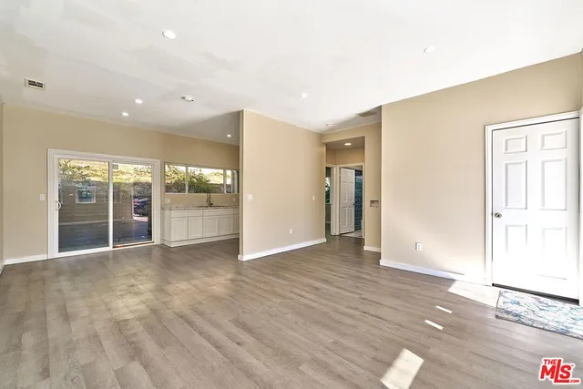 a kitchen with granite countertop a stove and a white countertops with wooden floor
