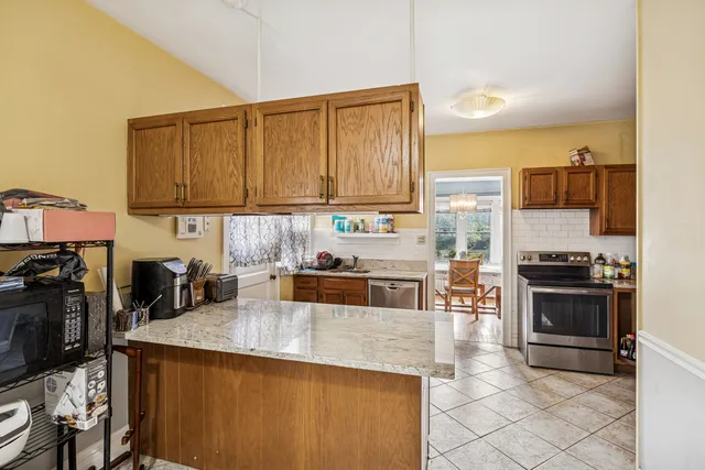 a kitchen with stainless steel appliances granite countertop a stove a sink a microwave and refrigerator