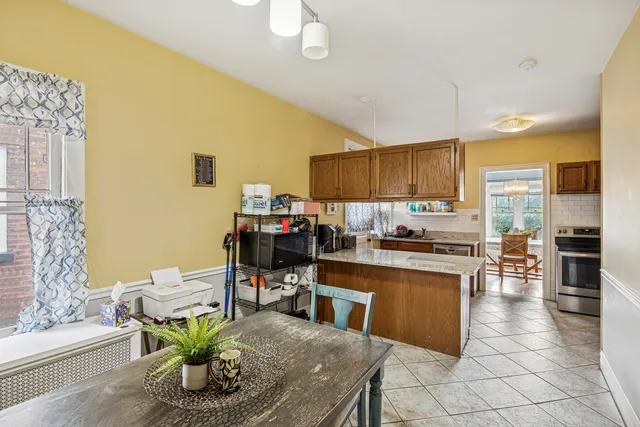 a kitchen with stainless steel appliances kitchen island granite countertop a table and chairs in it