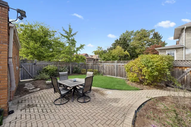a view of a chair and table in backyard of the house