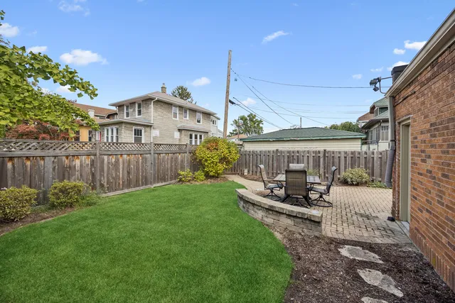 a view of a house with backyard and sitting area