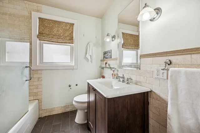 a bathroom with a sink a toilet and a mirror