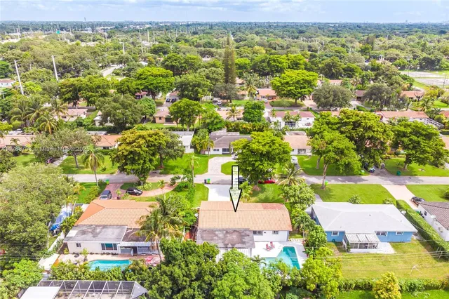 an aerial view of residential houses with outdoor space and swimming pool