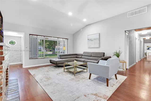 a living room with furniture and wooden floor