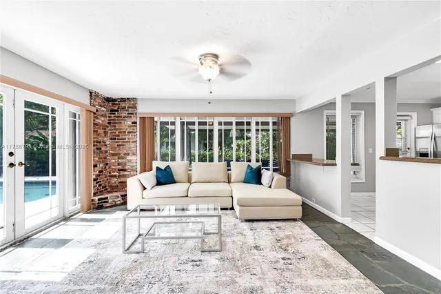 a living room with furniture large window and glass door
