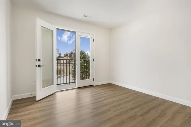 a view of a big room with wooden floor and windows