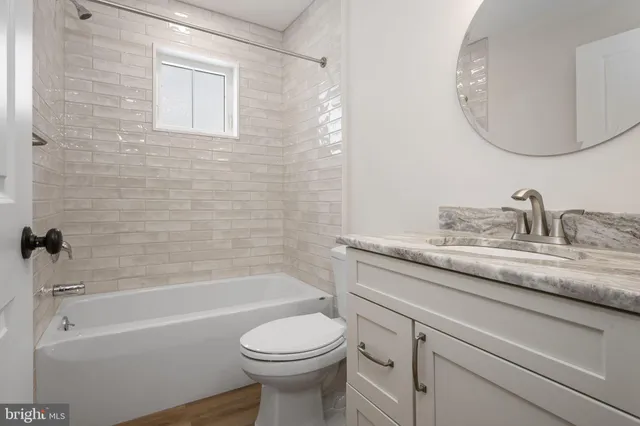 a bathroom with a granite countertop toilet a sink and bathtub