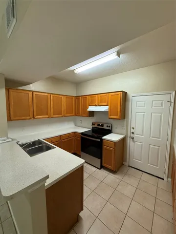a kitchen with a stove sink and cabinets
