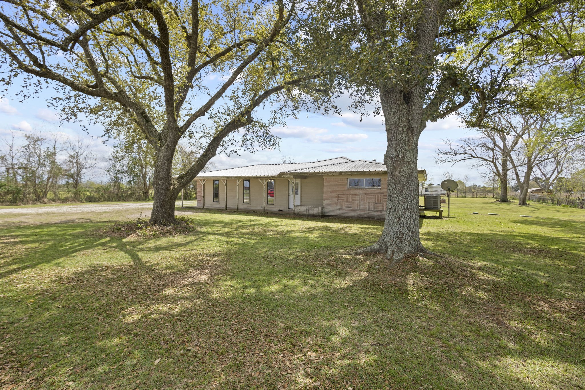 19961 Englin Road Winnie, TX 77665 - Photo 5 of 26 a backyard of a house with lots of green space and fountain