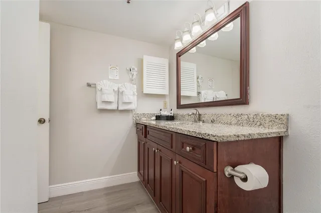 a bathroom with a granite countertop sink and a mirror