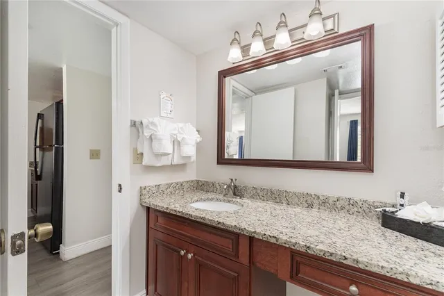 a bathroom with a granite countertop sink vanity and a mirror