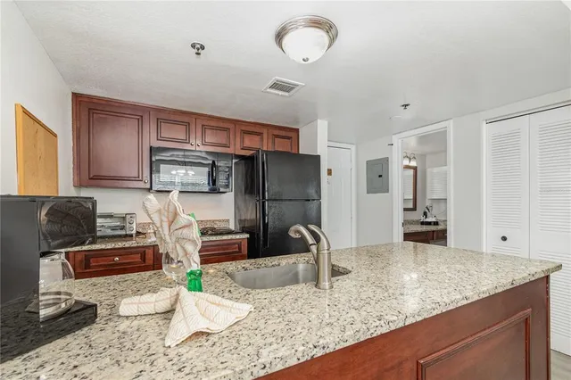 a kitchen with stainless steel appliances granite countertop a sink refrigerator and cabinets