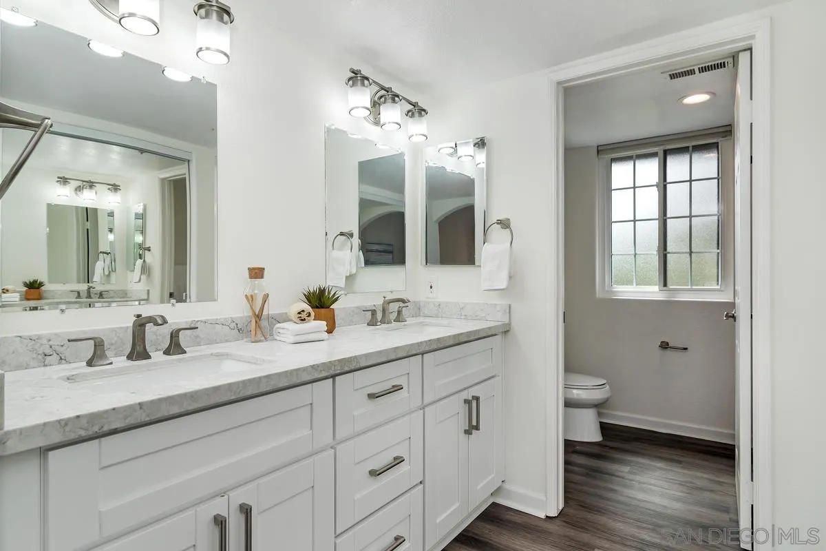 16470 Avenida Venusto, Unit F Rancho Bernardo, CA 92128 - Photo 21 of 30 a bathroom with double vanity sink a mirror and a toilet