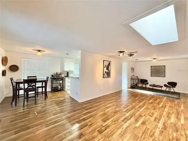 a kitchen with a dining table chairs and white cabinets